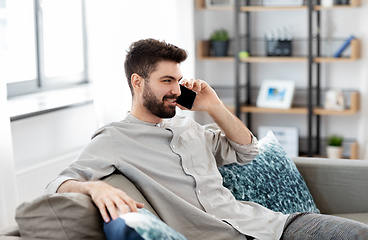 Image showing happy man calling on smartphone at home