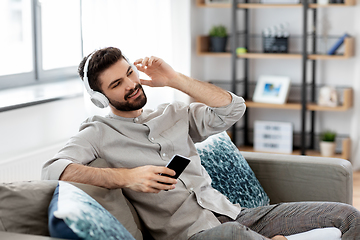 Image showing man in headphones listening to music on smartphone