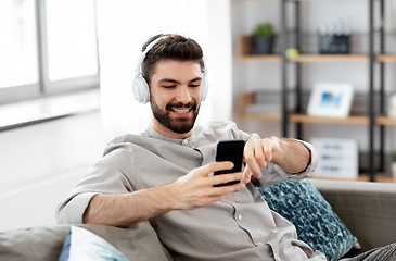 Image showing man in headphones listening to music on smartphone