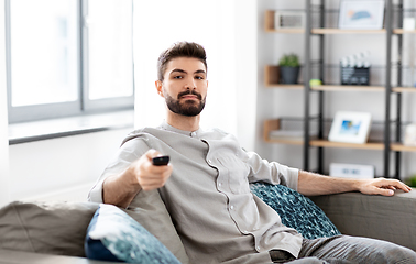 Image showing man with remote control watching tv at home