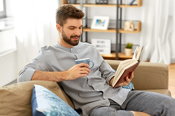 Image showing man reading book and drinking coffee at home