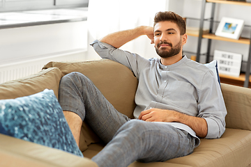 Image showing young man sitting on sofa at home