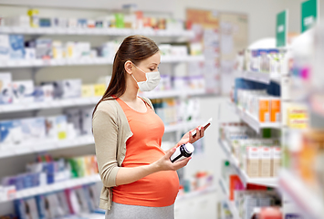 Image showing pregnant woman in mask with medicine at pharmacy