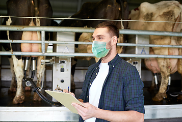 Image showing man in mask with clipboard and cows on dairy farm