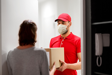 Image showing delivery man in mask giving parcel box to customer