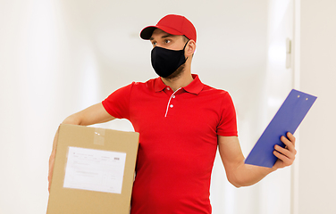 Image showing delivery man in mask with box and clipboard