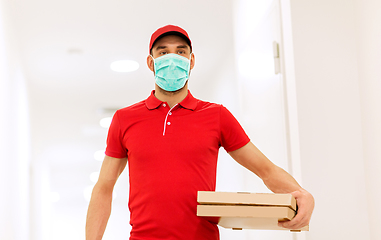 Image showing delivery man in mask with pizza boxes in corridor