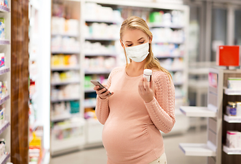 Image showing pregnant woman in mask with medicine at pharmacy