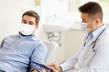 Image showing male doctor and patient in masks at hospital