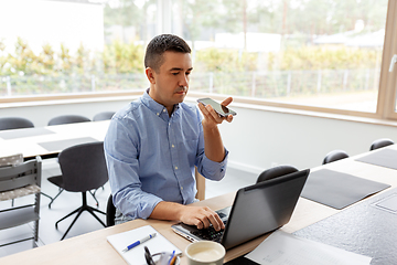 Image showing man with smartphone and laptop at home office