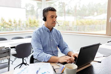 Image showing man with headset and laptop working at home