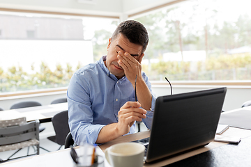 Image showing tired man with laptop working at home office