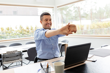 Image showing tired man with laptop stretching at home office