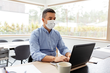 Image showing man in mask with laptop working at home office