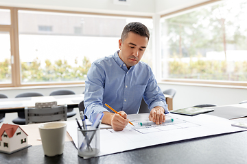 Image showing architect with blueprint working at home office