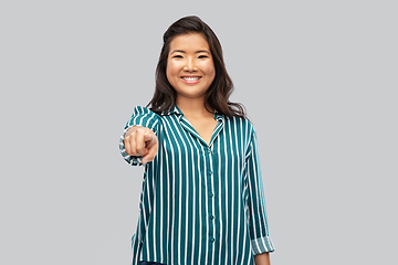 Image showing happy asian woman pointing finger to camera