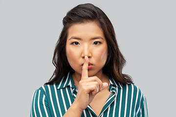 Image showing portrait of young asian woman making hush gesture