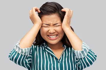 Image showing stressed asian woman holding to her head
