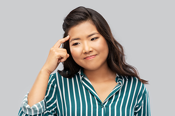 Image showing thinking asian woman over grey background