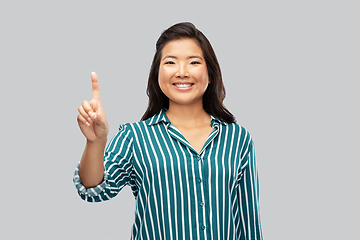 Image showing happy asian woman showing one finger up