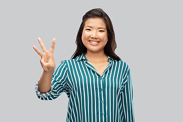 Image showing happy asian woman showing three fingers