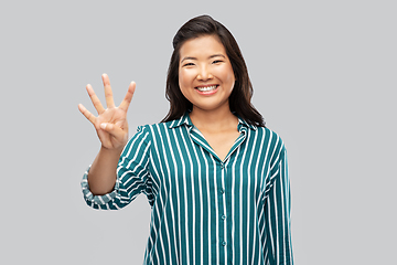 Image showing happy asian woman showing four fingers