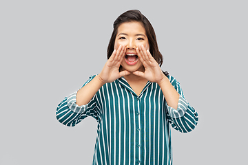 Image showing young asian woman calling for someone