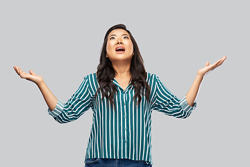 Image showing happy asian young woman looking up