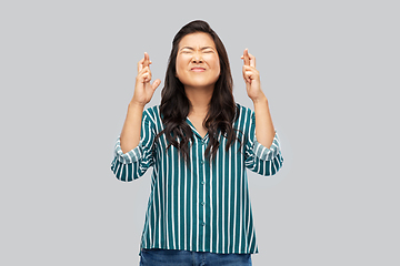 Image showing asian woman holding fingers crossed