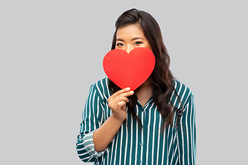 Image showing happy asian woman covering face with red heart