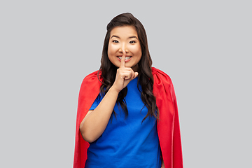 Image showing asian woman in superhero cape making hush gesture