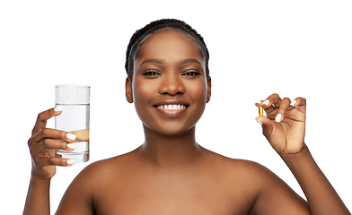 Image showing african woman with cod liver oil and water glass