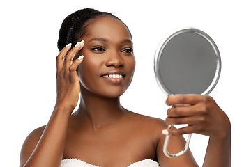 Image showing smiling african american woman looking to mirror