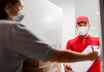 Image showing delivery man in mask and customer signing papers