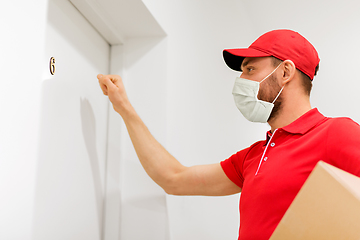 Image showing delivery man in mask with parcel knocking on door