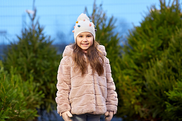 Image showing little girl choosing christmas tree at market