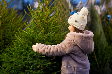 Image showing little girl choosing christmas tree at market