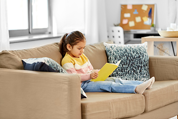 Image showing little girl reading book at home