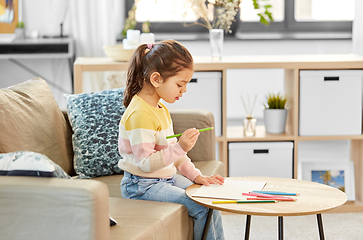 Image showing little girl drawing with coloring pencils at home