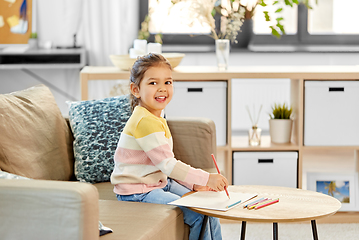 Image showing little girl drawing with coloring pencils at home