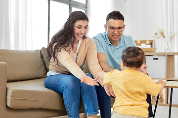 Image showing happy family with child sitting on sofa at home