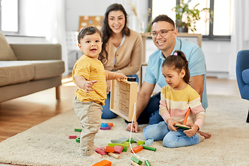 Image showing happy family palying with wooden toys at home