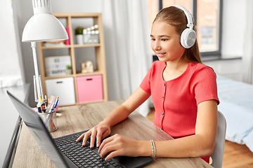 Image showing girl in headphones with laptop computer at home