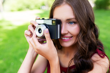 Image showing happy woman with camera photographing at park