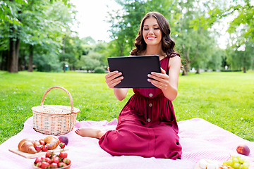 Image showing happy woman with tablet computer on picnic at park