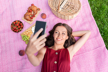 Image showing happy woman with smartphone taking selfie at park