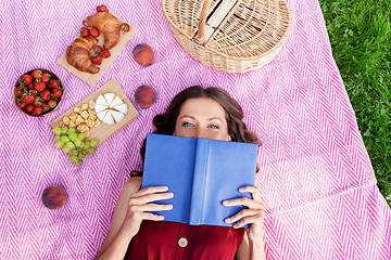 Image showing happy woman reading book at picnic in summer park