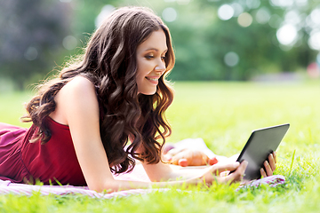 Image showing happy woman with tablet computer on picnic at park