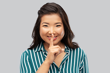 Image showing portrait of happy asian woman making hush gesture