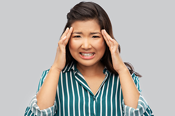 Image showing stressed asian woman holding to her head